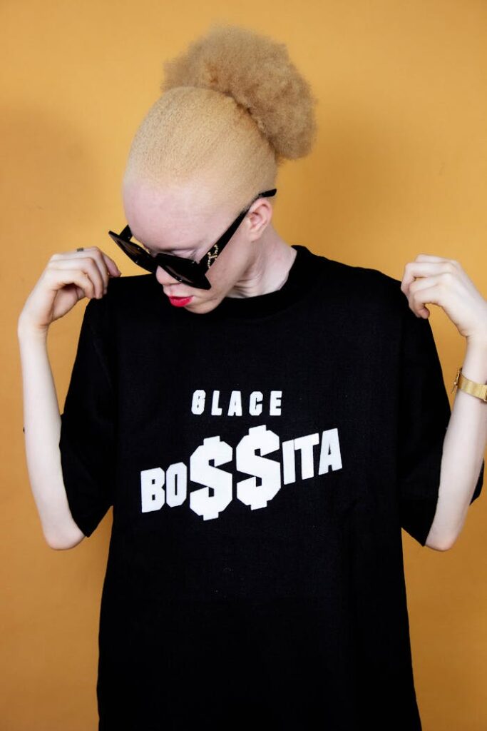 Fashionable woman wearing black t-shirt with bold text on yellow background.