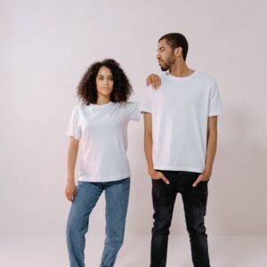Two young adults posing in casual blank t-shirts, holding a relaxed and confident stance.